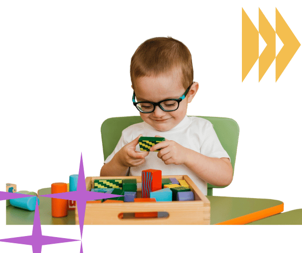 Young child focusing intently as they arrange multicolored building blocks on a low play table.