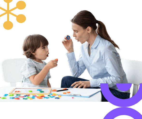 Child and therapist in a one-on-one positive behaviour support session, building trust and communication skills.