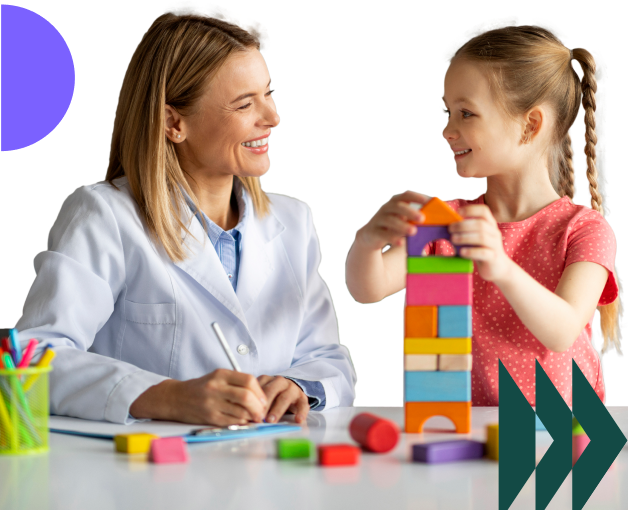 Behaviour support practitioner and young child building a tower with colourful blocks during a therapy session.