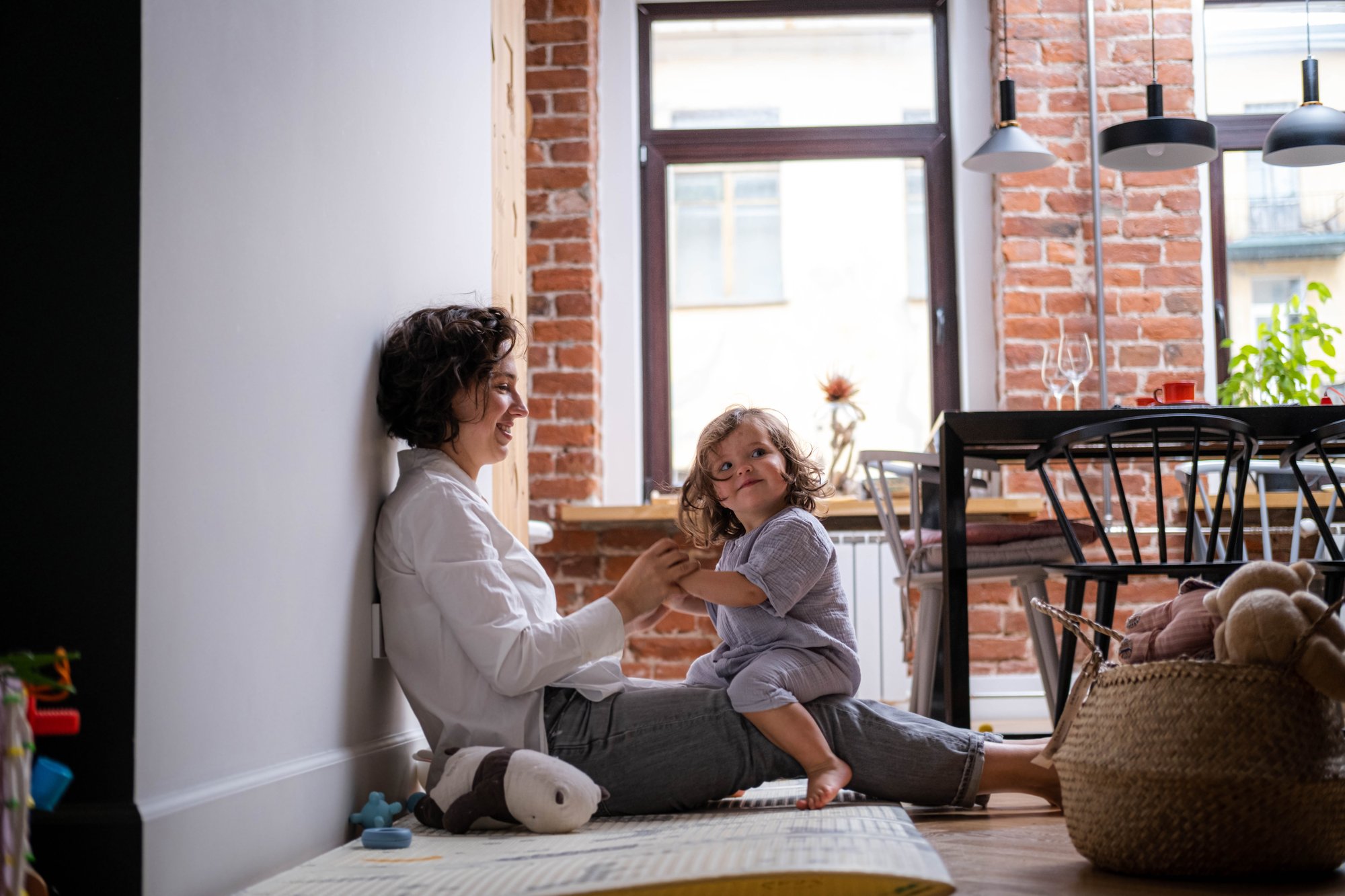 Mother and child playing together on the floor at home, sharing laughter and therapeutic bonding.