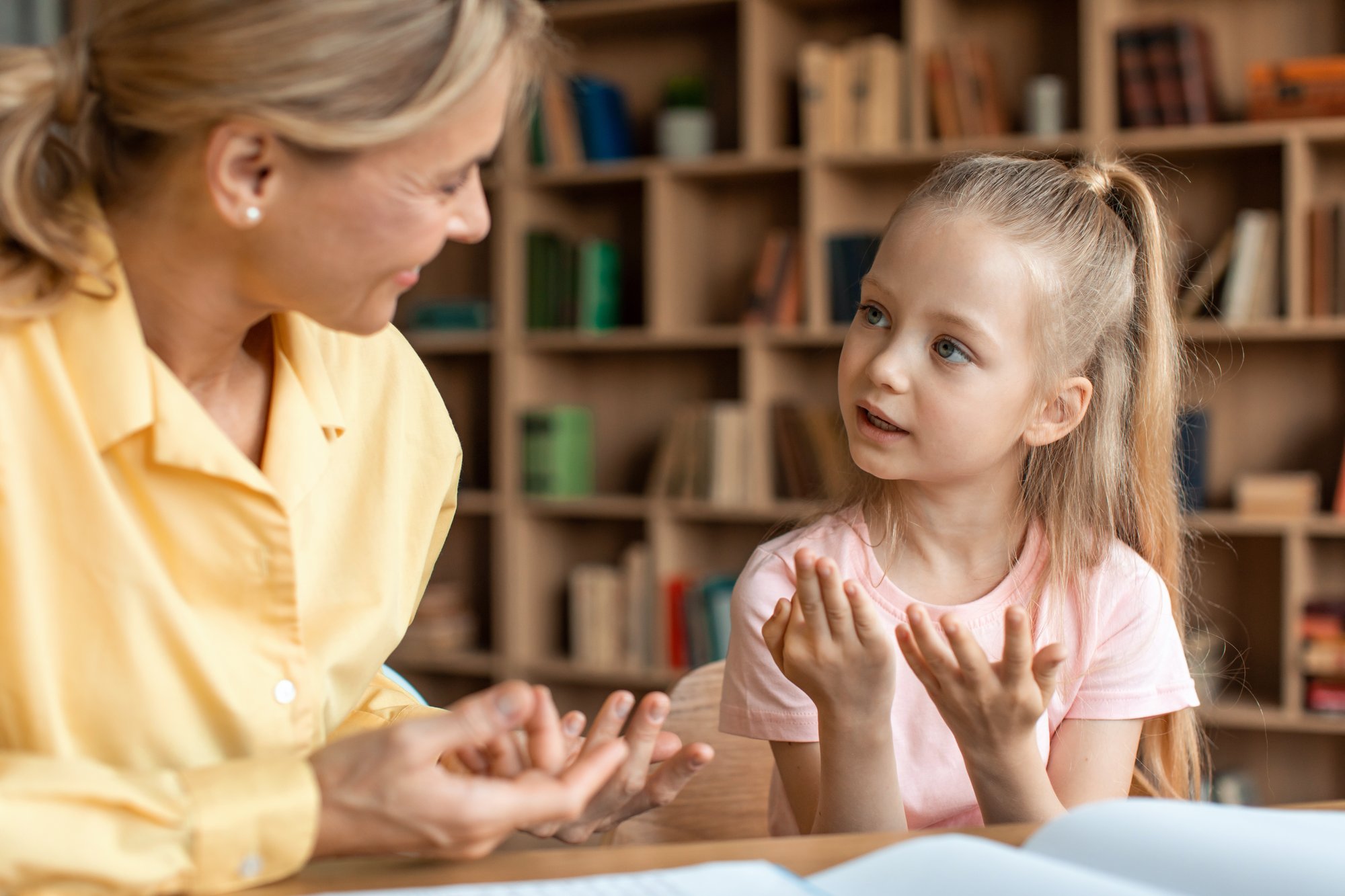 Young child facing a therapist, sharing thoughts in a calm one-on-one therapy conversation.