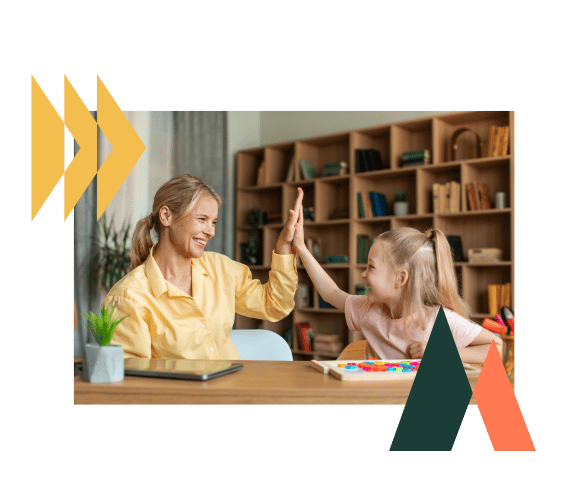 Therapist and child sharing a celebratory high five in a bright therapy room, fostering encouragement and trust.